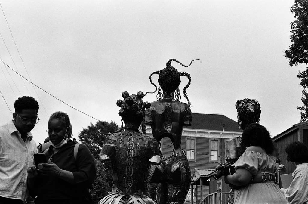 The sculptures seen from behind against the sky, with members of the team gathered around them.
